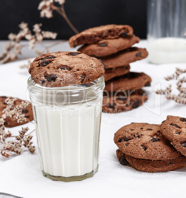 round chocolate cookie is a transparent glass with milk