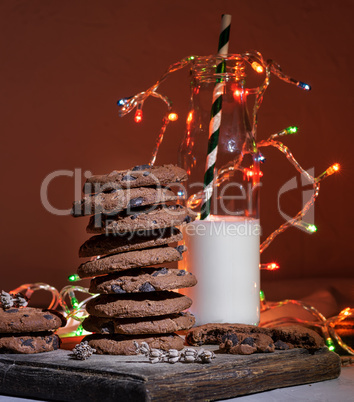 stack of chocolate round biscuits, a glass bottle with milk