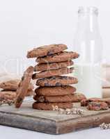 stack of round chocolate chip cookies on a brown wooden board,