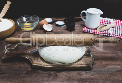 piece of white wheat flour dough on a brown board