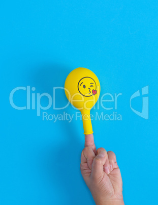 yellow inflated ball dressed on the middle finger of a human han