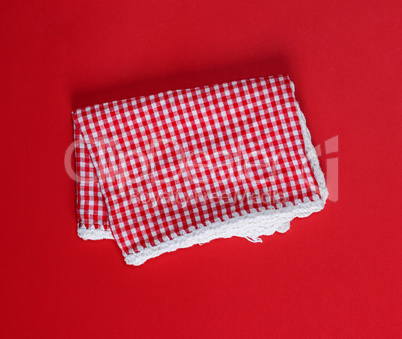 folded red cotton kitchen towel in the box on a red background