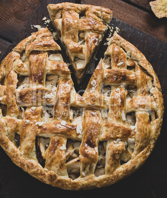 baked whole round apple pie on a brown wooden board