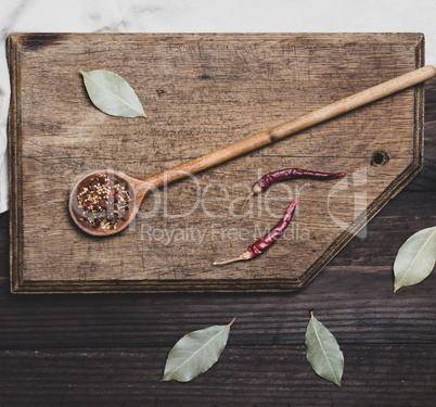 wooden spoon with  spices on a cutting board