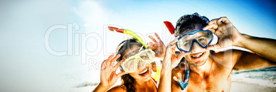 Couple posing with diving mask on beach