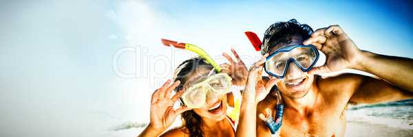 Couple posing with diving mask on beach