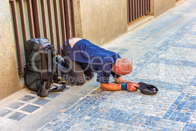 Sick homeless beggar on his knees on Old Town of Prague