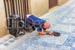 Sick homeless beggar on his knees on Old Town of Prague