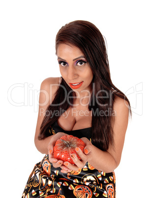 Happy woman holding a small pumpkin in her hands