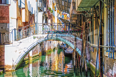 Venice narrow canal and a bridge over it in a typical backyard