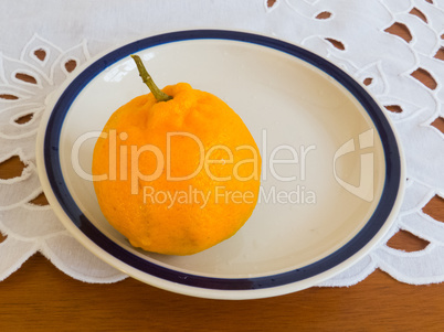 Ripe mandarin on porcelain dish, on lace towel.