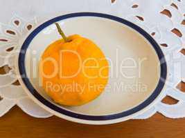 Ripe mandarin on porcelain dish, on lace towel.