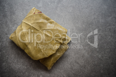 Raw tempeh wrapped in leaf, top view close up.