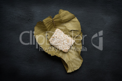 Fresh tempeh wrapped in leaf, top view.