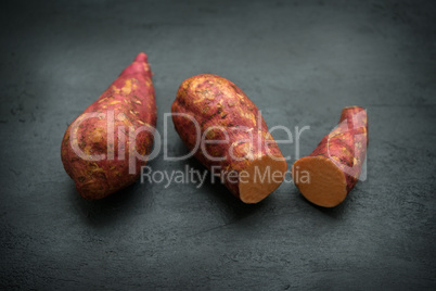 Fresh organic orange sweet potato on dark background.