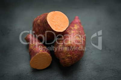 Fresh organic sweet potato on dark background.