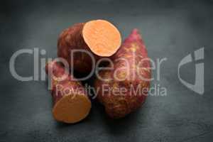 Fresh organic sweet potato on dark background.
