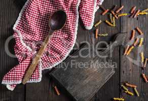 empty wooden cutting board, wooden spoon on a red towel
