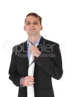 Young man standing in a suit fixing tie