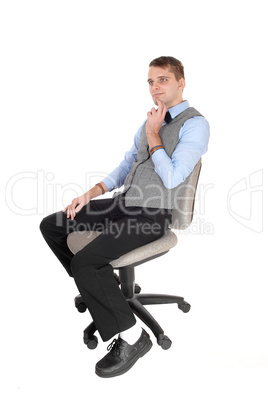 Man sitting in dress pants and vest, thinking