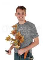 Young man working on autumn trees cutting