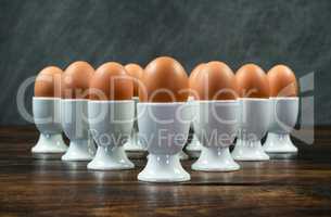 Ten Boiled Eggs in Egg Cups on a Table