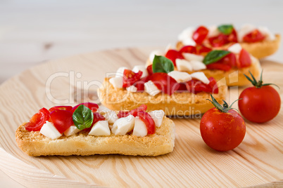 Closeup of Italian crostini with mozzarella, cherry tomatoes and basil