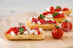 Closeup of Italian crostini with mozzarella, cherry tomatoes and basil