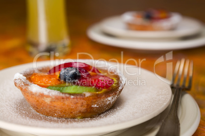 Small fruit tart on a plate and fork