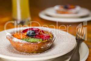 Small fruit tart on a plate and fork
