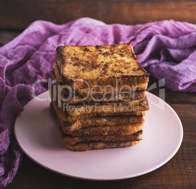 fried French toast on a ceramic pink plate