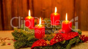 Weihnachten Adventskranz mit 4 brennenden Kerzen auf altem Holz