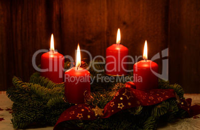 Weihnachten Adventskranz mit 4 brennenden Kerzen auf altem Holz