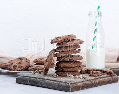 stack of round chocolate chip cookies and a glass bottle with mi