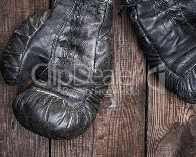pair of very old shabby black leather boxing gloves