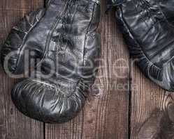 pair of very old shabby black leather boxing gloves