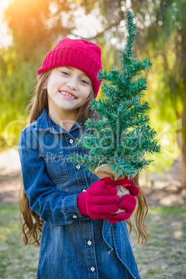 Cute Mixed Race Young Girl in Red Cap and Mittens Holds Tiny Tree