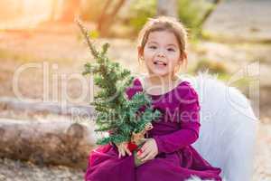 Cute Mixed Race Young Baby Girl Holding Small Christmas Tree