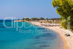 Sunny beautiful summer view of the sandy beach with Greek blue s