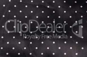 black fabric background with white dots