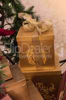 Gold wrapped Christmas presents with a gold ribbon tied into a b
