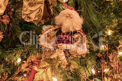 Santa Clause ornament on a Christmas tree with white lights