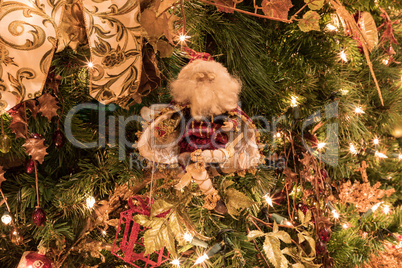 Santa Clause ornament on a Christmas tree with white lights