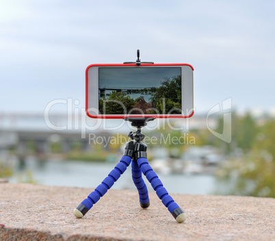smartphone stands on tripod and shoots landscape