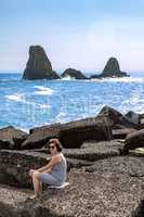 Woman in front of island at Aci Trezza, Sicily
