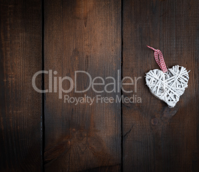 white wicker heart on a brown wooden plank background