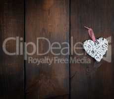 white wicker heart on a brown wooden plank background