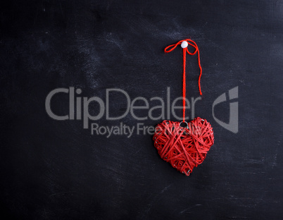 small wicker red heart hangs on a rope