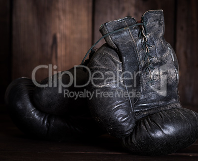 pair of very old shabby black leather boxing gloves