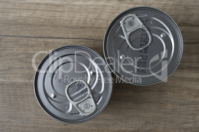 Tin cans for food on wooden background.